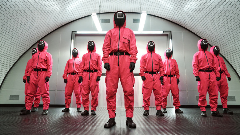 A group of guards standing in the hallway playing a game of squid