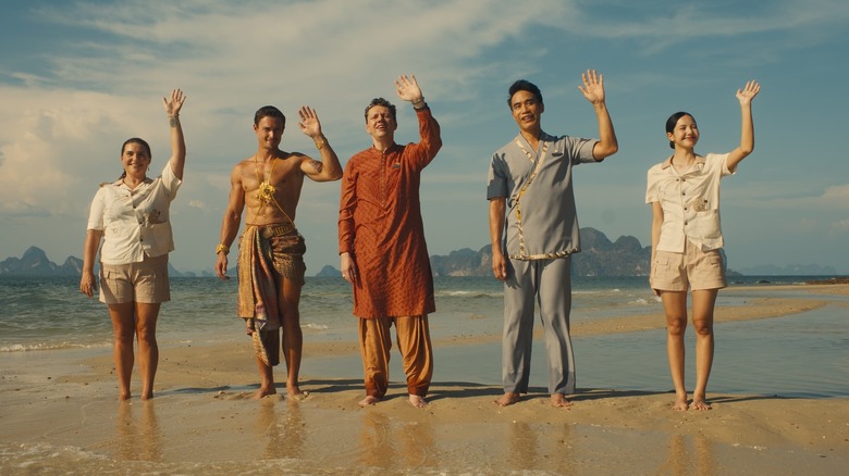 Pam, Valentin, Fabian, Pornchai, and Mook waving on the beach in The White Lotus