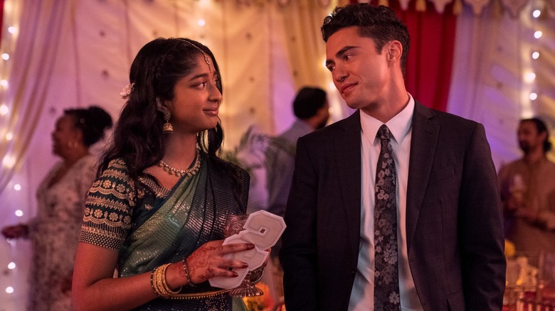 Maitreyi Ramakrishnan's Devi, wearing a sari, smiles at suit-clad Paxton (Darren Barnet) in Never Have I Ever