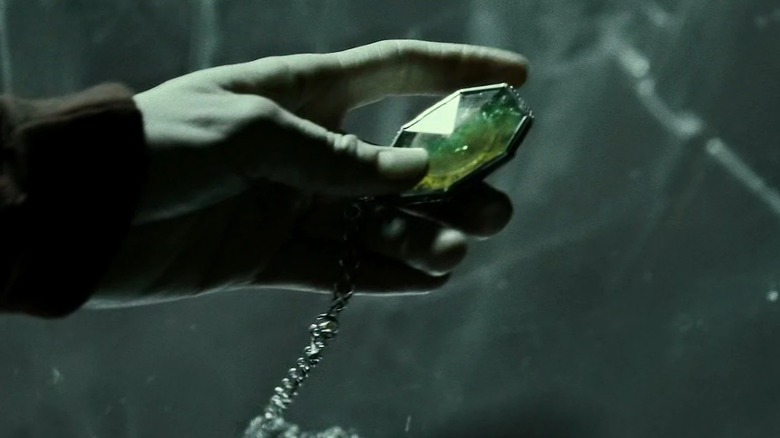 Hand holding R.A.B.'s locket in Harry Potter and the Deathly Hallows: Part 1