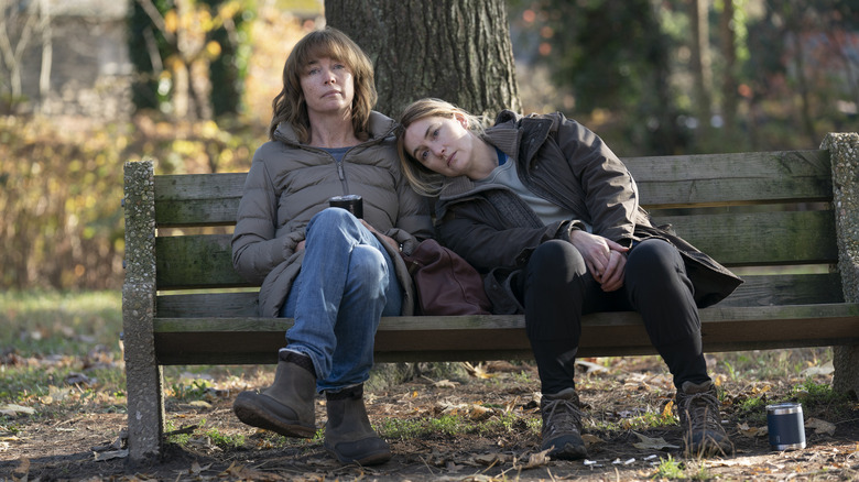 Lori and Mare sitting on a park bench in Mare of Easttown