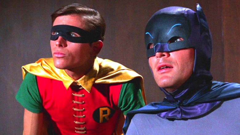 Robin e Batman, olhando atentamente para alguém fora da tela na série de TV Batman de 1966