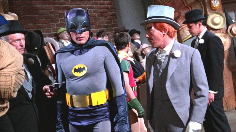 Batman is caught in a gun point by a Thug as the mad Hatter looks like. Robin is behind them, a bitch is also threatened. They are in a comment. From the 1966-CI6 Batman TV series