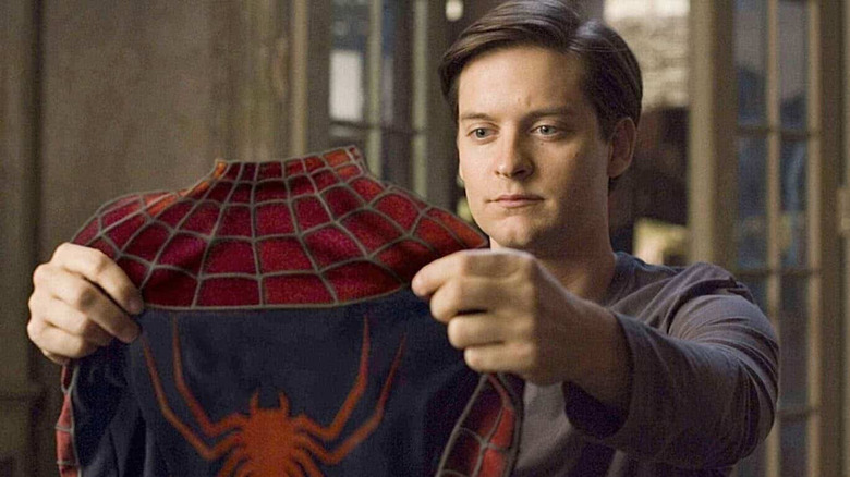 Tobey Maguire admires his Spider-Man suit.