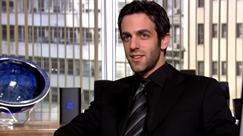 Ryan (with stubble) sitting at his desk on The Office