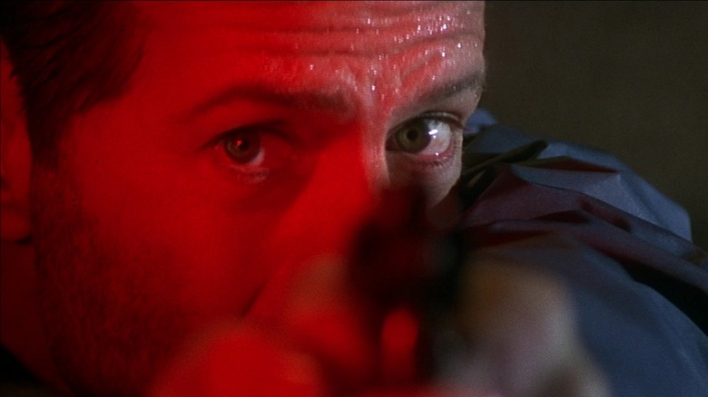 Bruce Willis as John McClane firing his gun in Die Hard with a Vengeance