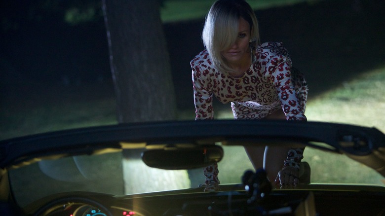 Malkina from 'The Counselor,' looking positively feline, climbing up the windshield of a convertible car