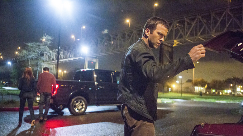 Lucas Black as Christopher with a surprised look on his face as he opens a car's trunk in the NCIS: New Orleans episode You'll Do