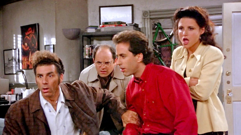 Kramer, George, Jerry, and Elaine, looking at something with confusion and disgust on Seinfeld