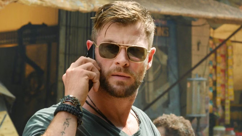 Chris Hemsworth takes a call on his cell in Extraction