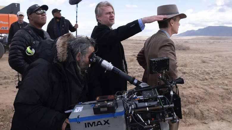 Christopher Nolan directs his camera crew on the set of Oppenheimer as Cillian Murphy looks off into the distance