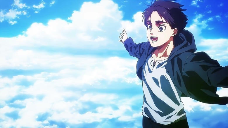 A young Eren extends his arms to the wind, smiling in Attack on Titan