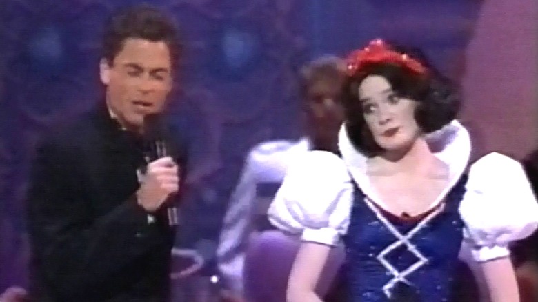 Rob Lowe and an actress dressed up as Snow White holding microphones and singing on the stage of the 1989 Oscars