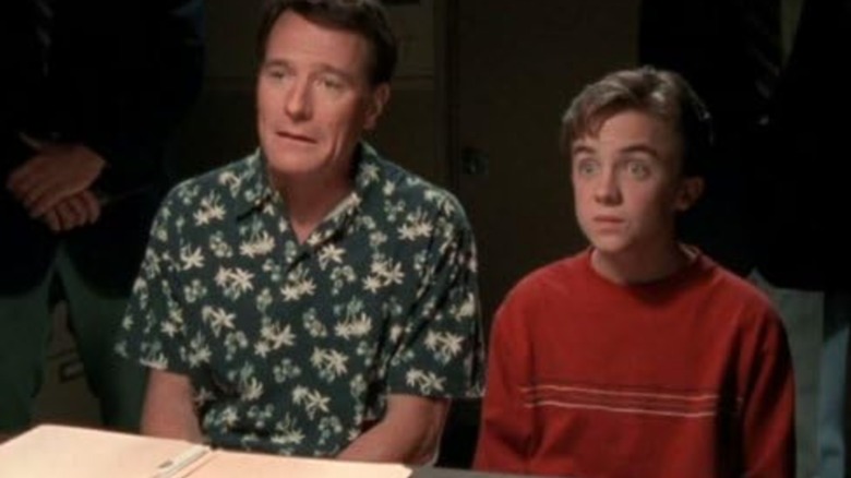 Bryan Cranston's Hal and Frankie Muniz's Malcolm look surprised at an interrogation table in Malcolm in the Middle