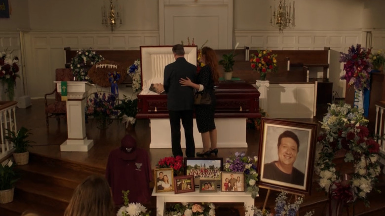 People grieving over the open casket of George Cooper, played by Lance Barber