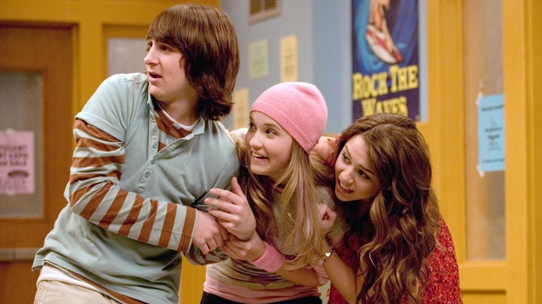 Oliver, Lily, and Miley linking arms and looking towards the left in astonishment on Hannah Montana