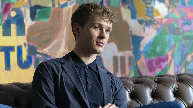 Robert sitting on a couch in front of a mural on Industry