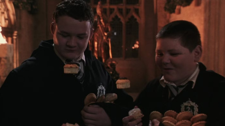 Crabbe and Goyle, snacking on pilfered treats. Magical cupcakes float in front of them.