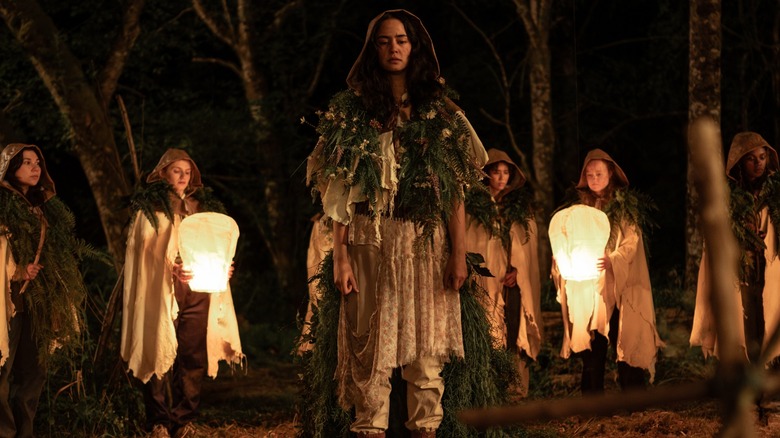 Lottie in witchy clothing surrounded by girls with lanterns in Yellowjackets