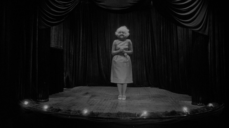 The Lady in the Radiator standing on a stage in Eraserhead