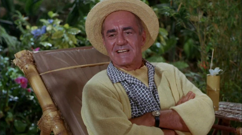 Jim Backus' Thurston Howell III sits in a sun chair with arms folded in Gilligan's Island