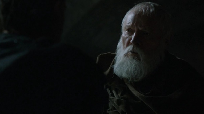 Julian Glover's Maester Pycelle looks at a figure in the darkness in Game of Thrones