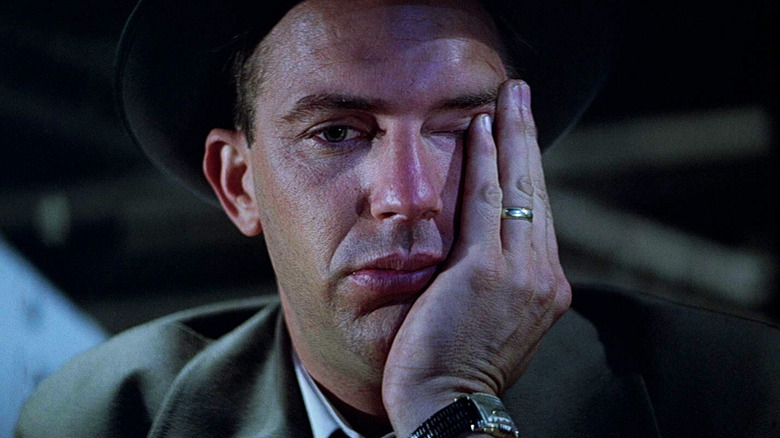 Kevin Costner's Eliot Ness holds a hand to his face in The Untouchables