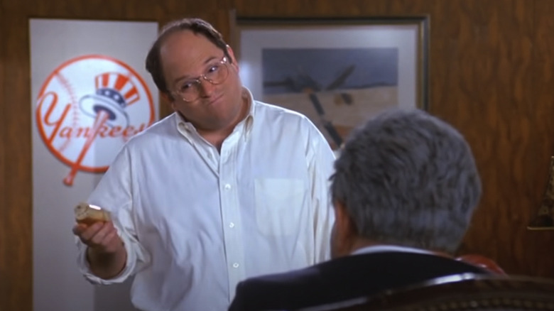 Jason Alexander shrugs in the Yankees' office as George Costanza in Seinfeld