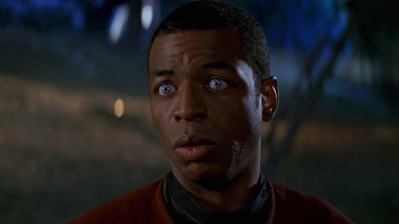 Geordi em pé ao ar livre à noite em Star Trek: Primeiro contato