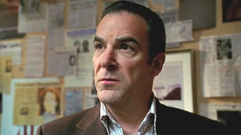 Jason Gideon stands in front of the ads with photos and newspaper clippings in criminal minds