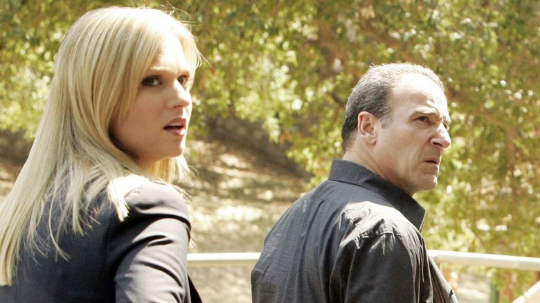 JJ Jareau and Jason Gideon, standing outside near a field, stare at something behind them on Criminal Minds