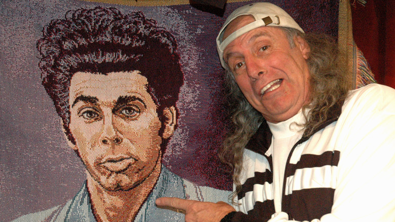 Kenny Kramer stands next to a portrait of Cosmo Kramer from Seinfeld