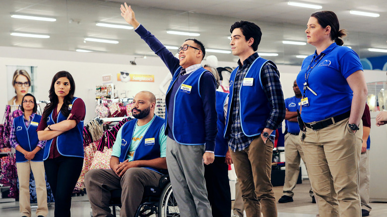 Mateo raises his hand with the other Cloud 9 employees at the Superstore