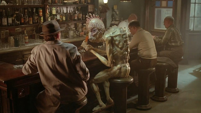 Bill Lee sits at the bar with an alien in Naked Lunch