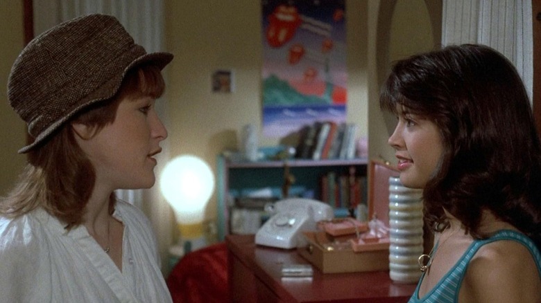 Kathleen Wilhoite in a brown hat, speaking to Phoebe Cates, sitting opposite her in a bedroom, in Private School