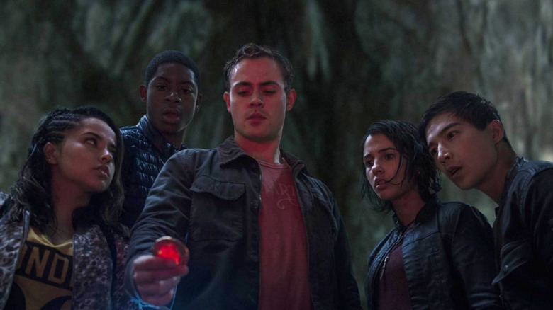 Jason holding a power coin while the other Rangers look on in Power Rangers