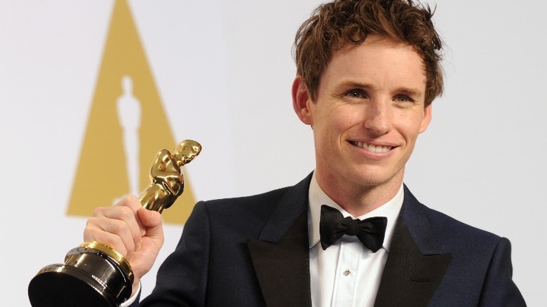 Eddie Redmayne holding his Oscar