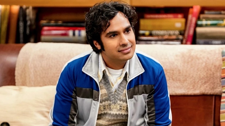 Raj with curly hair sitting on Leonard and Sheldon's couch on The Big Bang Theory