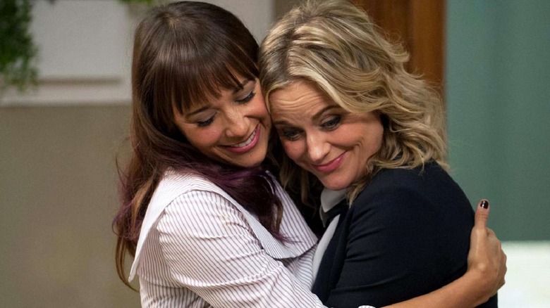 Ann Perkins and Leslie Knope embrace happily on an episode of 