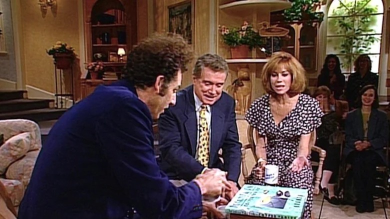 Michael Richards as Kramer shows off his coffee table book to Regis Philbin and Kathie Lee Gifford in Seinfeld