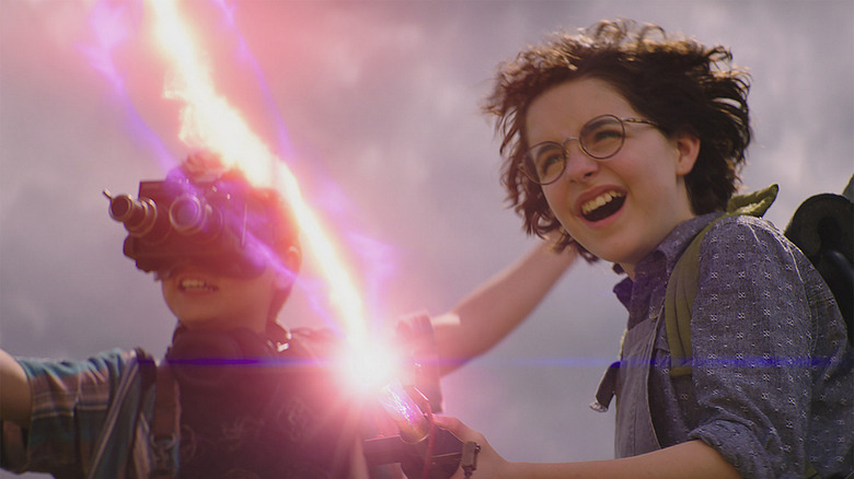 Phoebe and Trevor using a proton pack in Ghostbusters: Afterlife