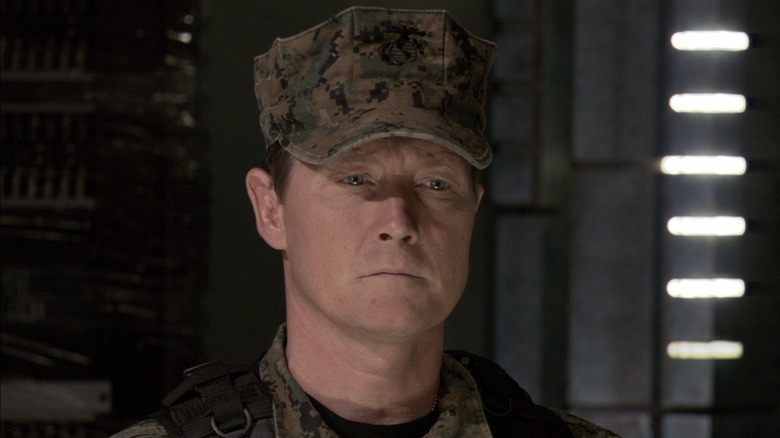 Robert Patrick's Colonel Marshall Sumner stands wearing a camouflage military cap in Stargate Atlantis