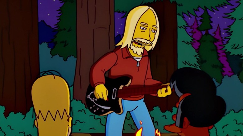 Animated Tom Petty with an electric guitar, singing a rock song by a campire. Homer Simpson and Apu watch.