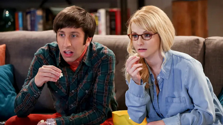 Howard and Bernadette eating popcorn and watching TV on The Big Bang Theory