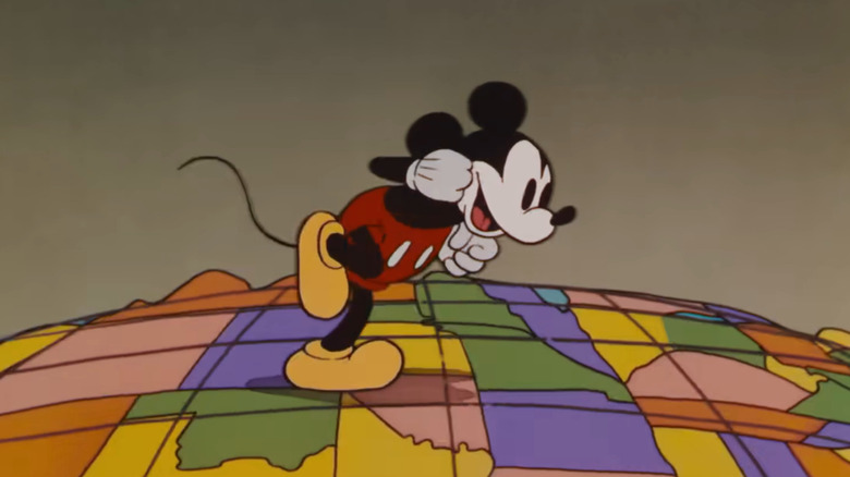 Mickey walking across a globe