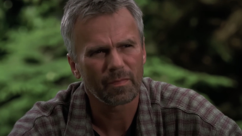 Richard Dean Anderson's Jack O'Neill looks across frame against a green background in Stargate SG-1