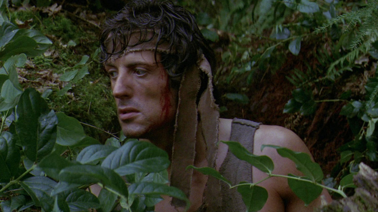 John Rambo hiding in the forest in First Blood