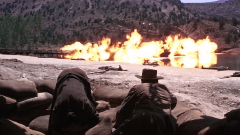 Blondie (Clint Eastwood) looks on at the explosion while Tuco (Eli Wallach) hides