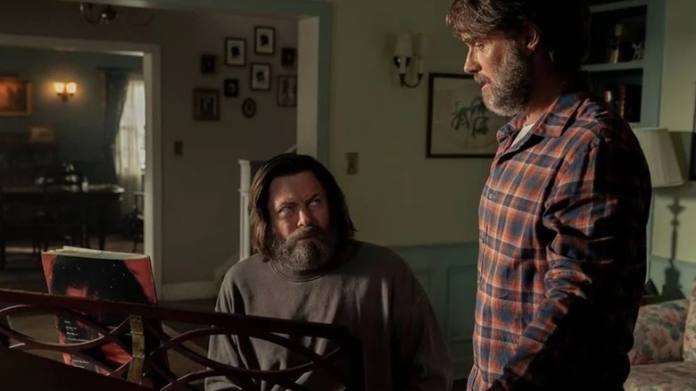 Nick Offerman's Bill sits at a piano, looking at Murray Bartlett's Bill in The Last of Us