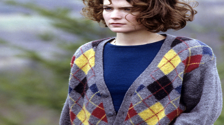 Donna Hayward standing on a hillside in a blue top and gray cardigan